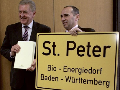 Bürgermeister Schuler und Wirtschaftsminister Pfister mit Werbeschild Bioenergiedorf